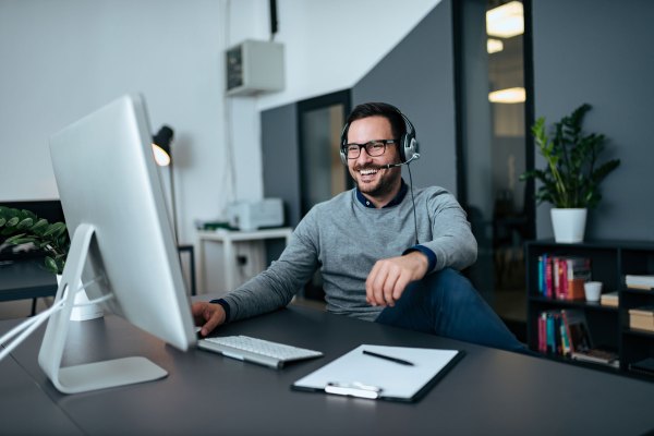 Handsome casual businessman talking online via headset.