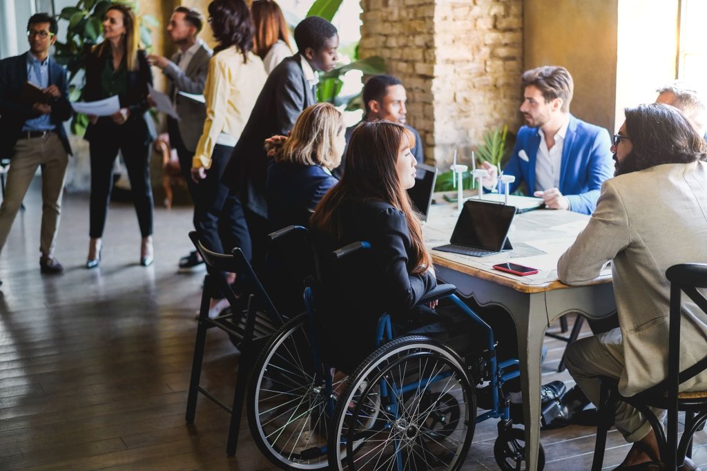 Multiracial business people working on sustainable innovation project - Focus on asian woman sitting on wheelchair