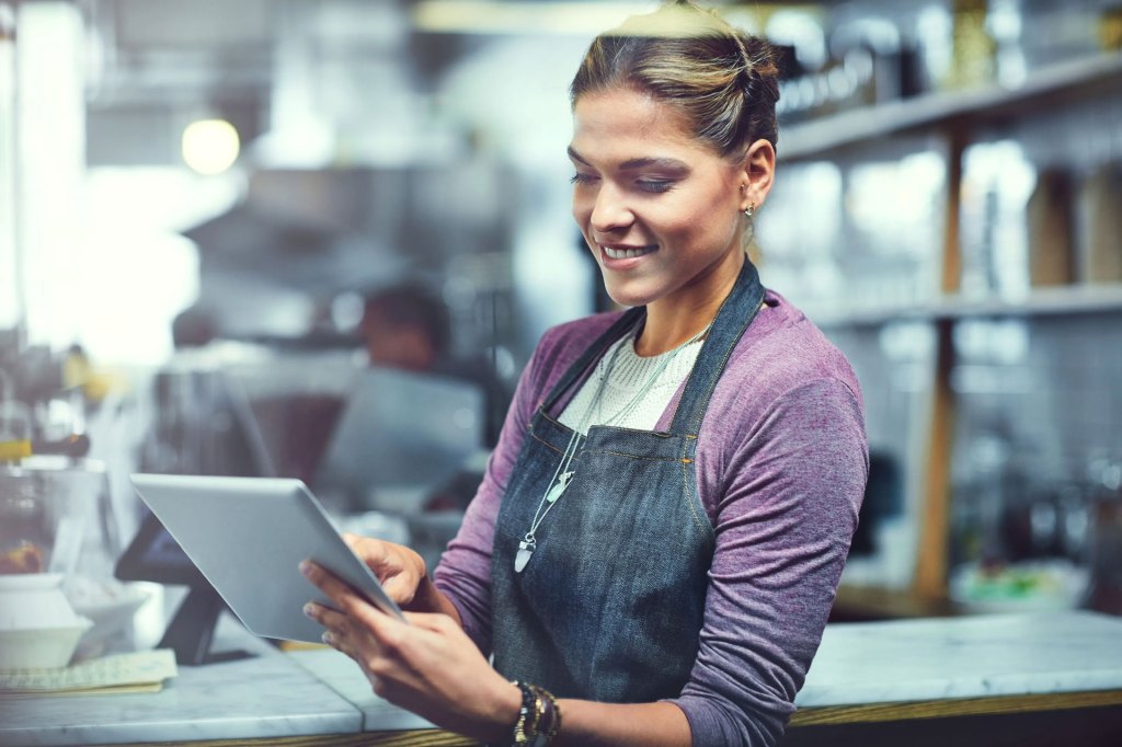 Shot of a young woman using a digital tablet in the store that she works at